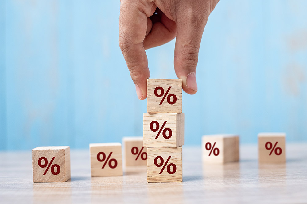 business man Hand putting wood cube block with percentage symbol icon